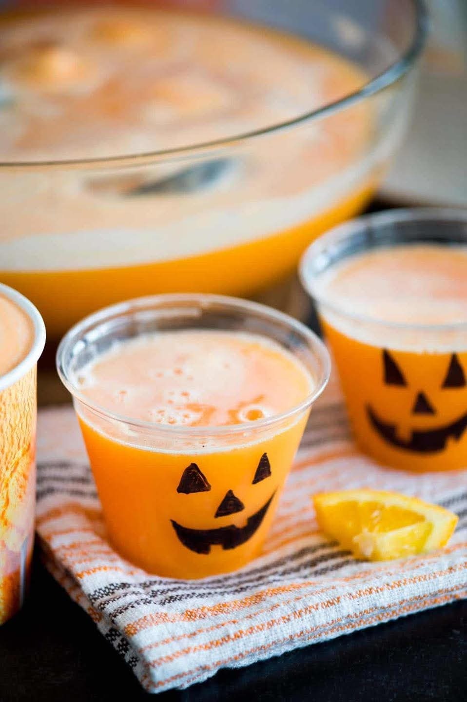 Pumpkin-themed cocktail with orange glow and Jack-o'-lantern, Galveston bar at night